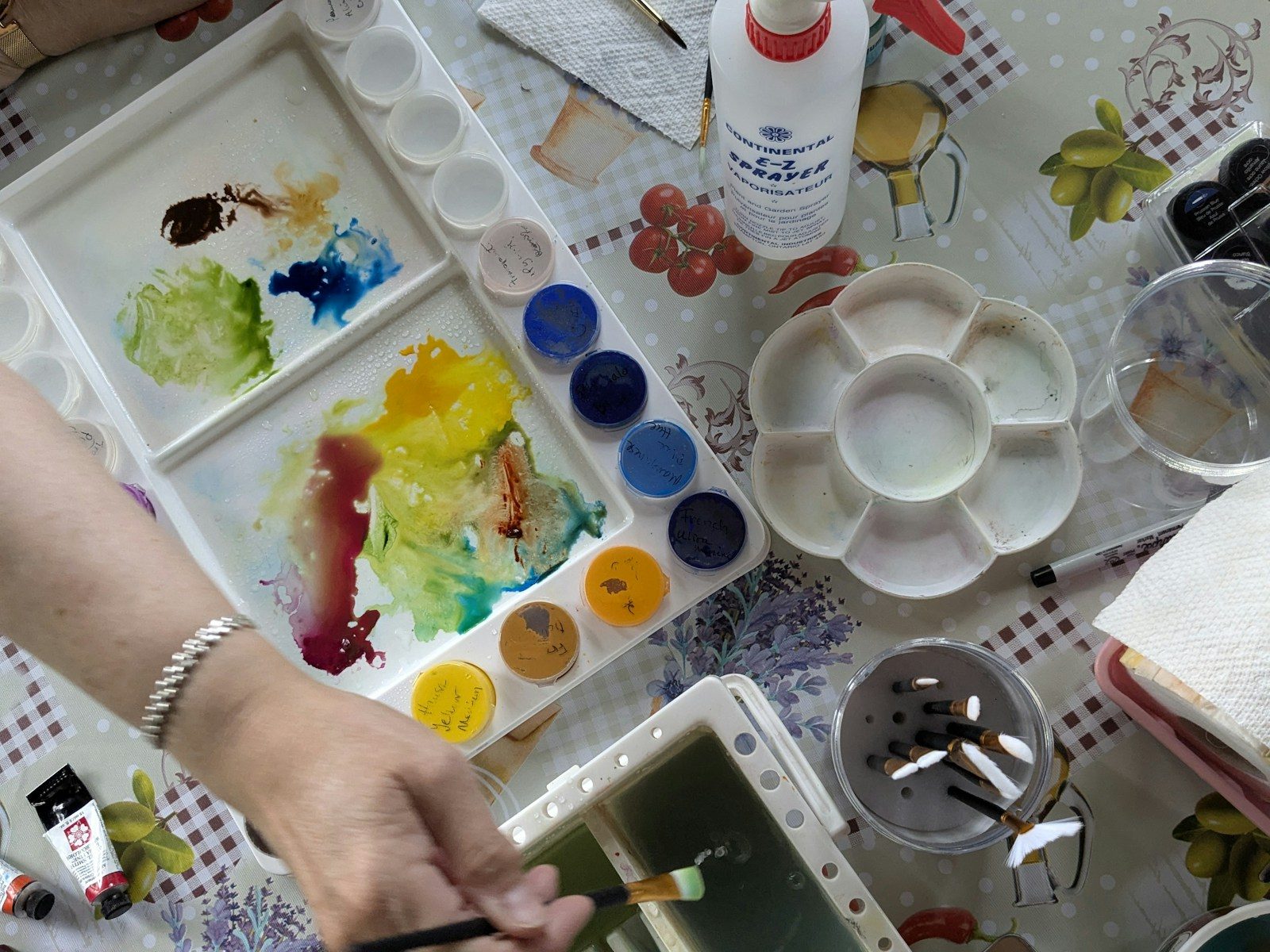 Zwei Personen malen nebeneinander mit Aquarellfarben, Blick von oben
