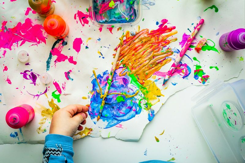 Kinderhände mit bunten Fingerfarben auf Papier